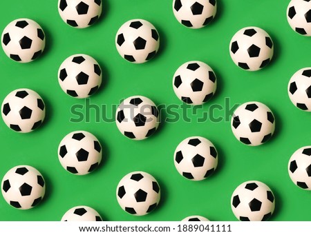 Geometric pattern made with soccer balls on green background
