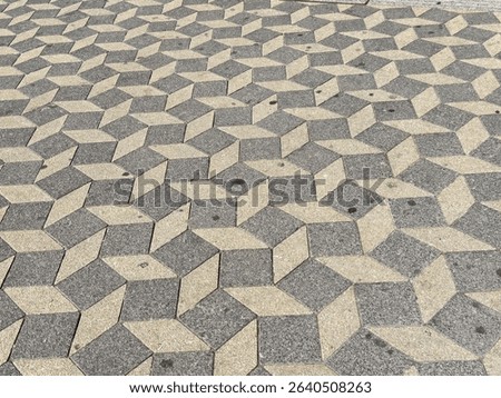 Geometric patterned stone pavement with 3d optical illusion in urban setting.