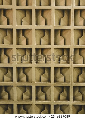 
A geometric patterned wall. The design features repeated three-dimensional shapes that resemble stars or crosses, creating an intricate tessellation.