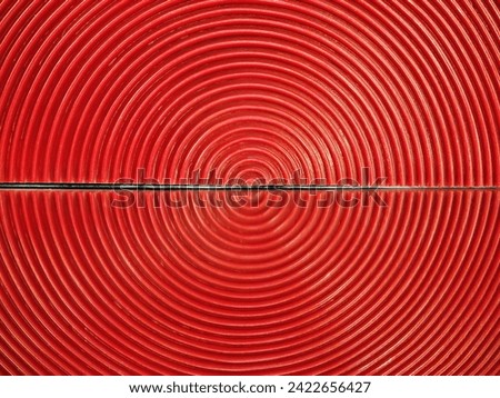 The geometric shape produced by a concentrated arrangement of red semi-circular planes reflected onto a mirror, resembling a red concentric circle pattern. Ideal for concentric circle backgrounds.