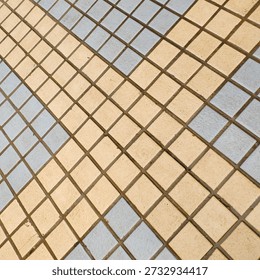 Geometric tile pattern with beige and gray squares arranged in diagonal grid on floor