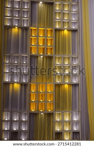Geometric wall panel with illuminated square niches and warm accent lighting