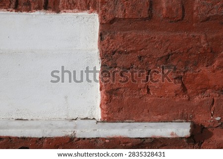 Geometric wall texture split between white painted surface and red brickwork at Northbrook Hall.