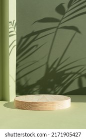 Geometric wooden podium on an abstract green background with a shadow of palm leaves. A scene with a geometric background. Backdrop for the product presentation. - Shutterstock ID 2171905427