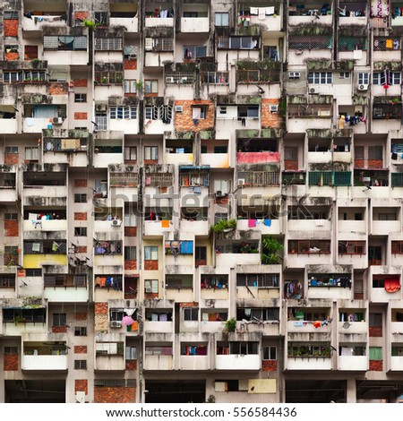 Geometrical pattern of multistory apartment house with group of windows and tenant lumber on balconies. Asian cities street background. Cheap accommodation,   social problems in overcrowded countries
