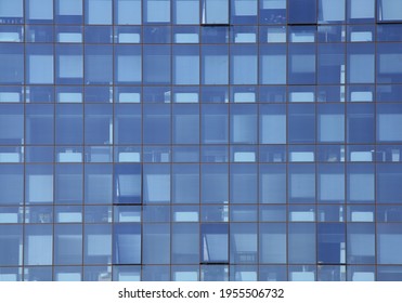 Geometry and abstract reflection of the blue facade. The exterior of modern offices: structure with glass windows.