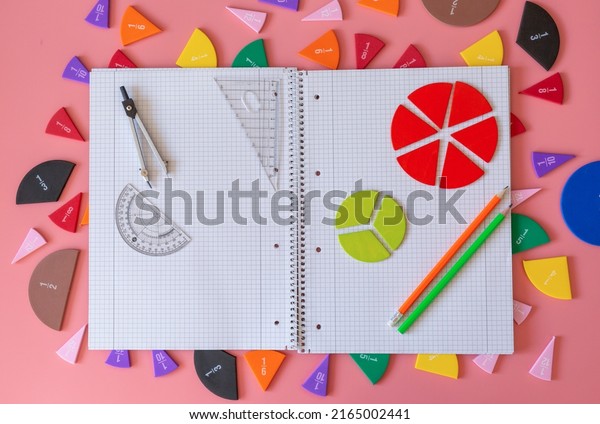 Geometry Set on open notebook.  Compass Drawing
Tool, ruler, pencils, multicolored fractions for mathematical
education. Math Drafting Dividers Tool, set for school, study. Back
to school concept