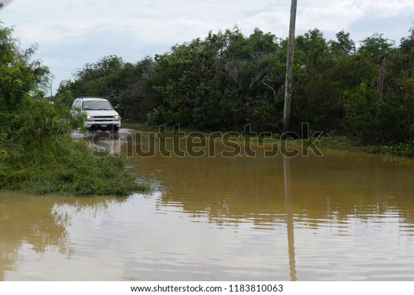GEORGE TOWN,\
BAHAMAS—JANUARY 2018: A car starts to drive through the flooded\
road in George Town, Exuma\
Cays.
