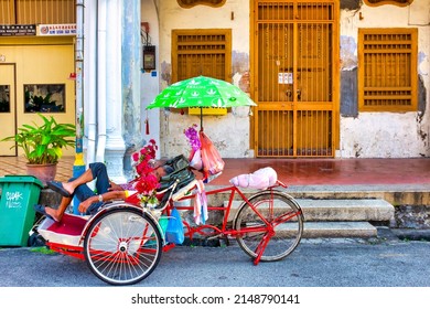 George Town, Malaysia - 03 04 2016: Cycle Rickshaw driver sleeping in George Street