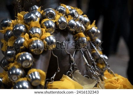Georgetown, Penang, Malaysia - February 05, 2023: Metal pots with offerings hooked on the back of a Hindu devotee at Thaipusam
