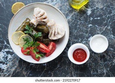 Georgian Dolma, Khinkali Dumplings And Dips, Above View On A Black Marble Background, Horizontal Shot