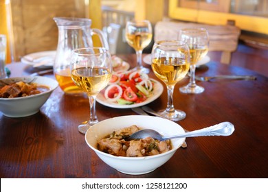 
Georgian Feast And Food In Tbilisi. White Homemade Wine On The Table Is A Traditional Dish - Tarragon Stew With Herb And Fresh Vegetable Salad