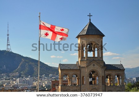 Georgian flag and the bell tower of The Holy Trinity Cathedral of Tbilisi, Sameba