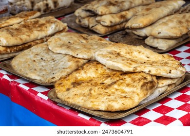 Georgian khachapuri set, flatbreads with cheese, spinach, mushrooms at street market. Golden brown appetizing khachapuri closeup