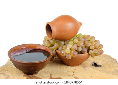 Georgian traditional decorative jug and cups for wine with grape on the wooden log slice with isolated background