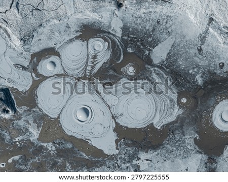 Geothermal mud pots boiling and creating unique textures in the volcanic landscape