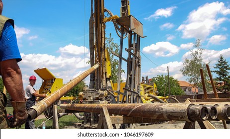 Geothermal Well Drilling.
Drilling Geothermal Well For A Residential Geothermal Heat Pump. Workers On Drilling Rig. Worker Prepares To Lift A Drill Pipe On A Drilling Rig.