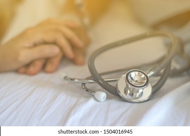 Geriatric Doctor Or Geriatrician Concept. Doctor Physician Hand On Happy Elderly Senior Patient To Comfort In Hospital Examination Room Or Hospice Nursing Home Or Wellbeing County. 