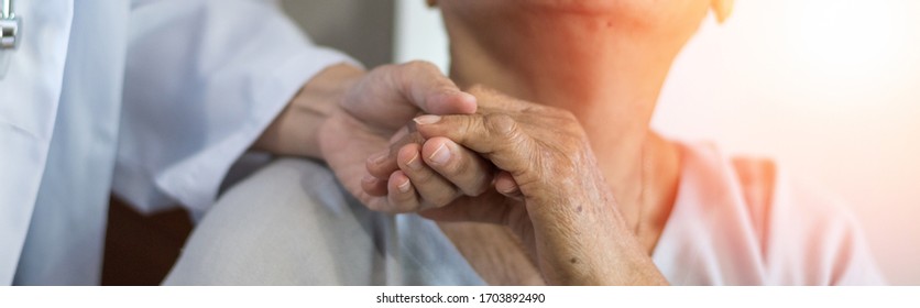 Geriatric doctor or geriatrician concept. Doctor physician hand on happy elderly senior patient to comfort in hospital examination room or hospice nursing home or wellbeing county. 