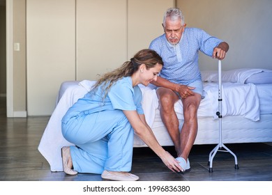 Geriatric Nurse Helps Senior With Walking Aid To Put On Shoes In A Nursing Home Or Hospital