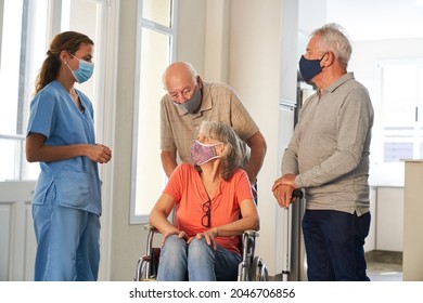 Geriatric nurses and seniors with face masks because of Covid-19 and coronavirus in the retirement home - Powered by Shutterstock