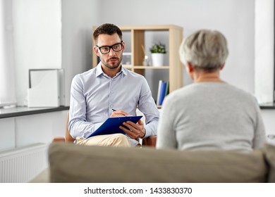 geriatric psychology, mental therapy and old age concept - psychologist with clipboard taking notes and listening to senior woman patient at psychotherapy session - Shutterstock ID 1433830370
