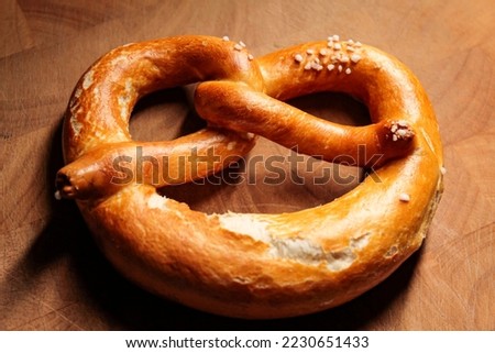 A German Bavarian pretzel on a wooden base in the kitchen.