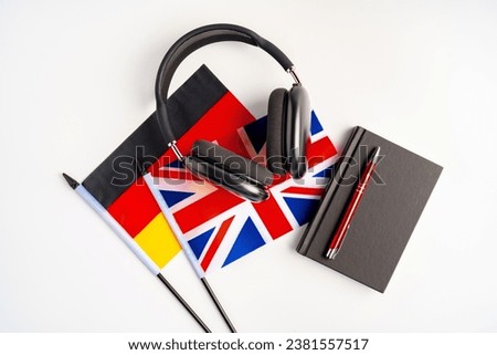 German and British flags with notepad on white background