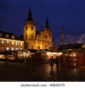 German Christmas Market At Night With People In Motion