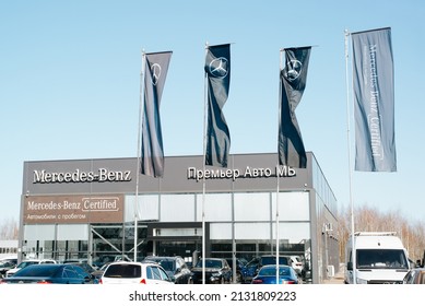 German Company Mercedes Benz Car Dealership Building And Flags With Logo Exterior On Sunny Day Outdoors. Smolensk, Russia 02.03.2022.