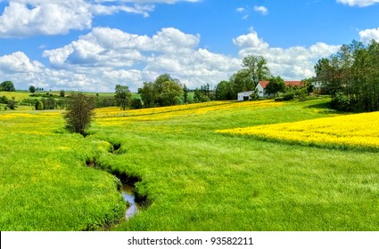 German Countryside Landscape With Creek And Yellow Canola Field