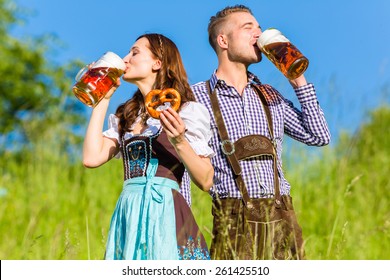 German couple in Tracht with beer and pretzel