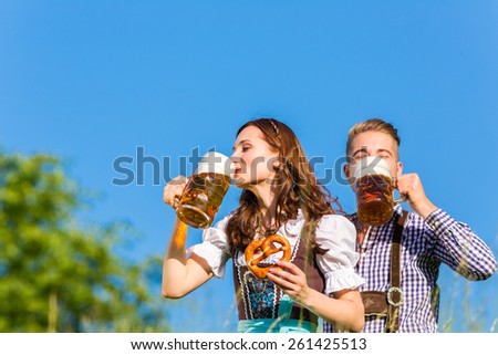 German couple in Tracht with beer and pretzel