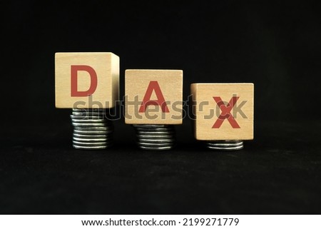 German DAX performance stock market index crash and bear market due to financial crisis and recession in Germany. Wooden blocks in with coins in dark black background.