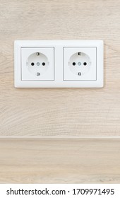 A German European type of double wall plug socket outlet on a wooden background with copy space