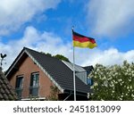 German flag blue sky house