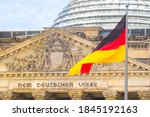 German flag on a background Reichstag building. The seat of the German Parliament or Bundestag, Berlin Mitte district. Inscription in German: To the German People