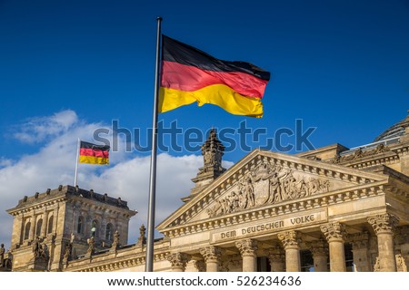 German flags waving in the wind at famous Reichstag building, seat of the German Parliament (Deutscher Bundestag), on a sunny day with blue sky and clouds, central Berlin Mitte district, Germany Foto d'archivio © 