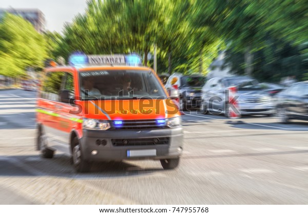 German Notarzt, emergency doctor\
car from fire department drives on a street to an\
accident.