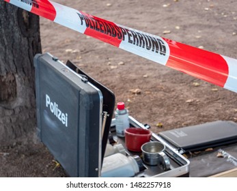 German Police Cordon Tape With Suitcase At The Scene