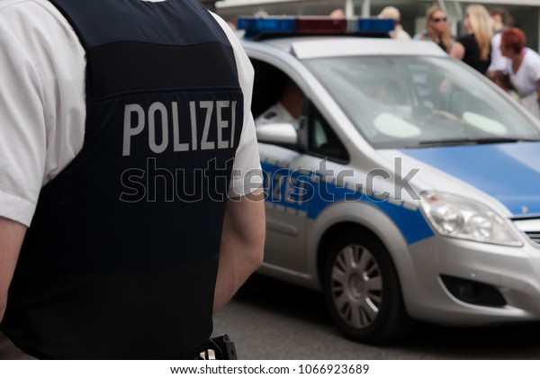 German police officer\
in front of a crowd