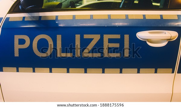 German police (german: Polizei) sign in white letters\
on a police car