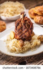 German Pork Knuckle With Sauerkraut And Baked Potatoes.