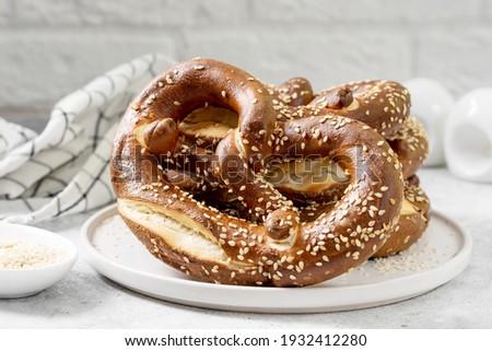 German Pretzels with sesame seeds on the light gray kitchen background. Brezel on the table