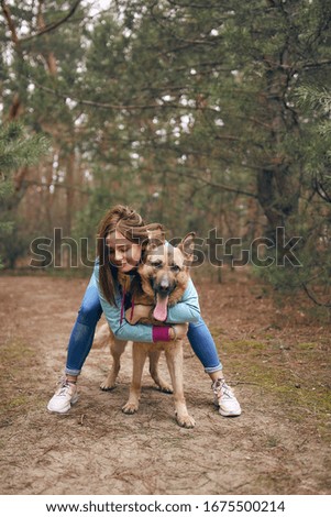 
German shepherd and girl in a pine forest
