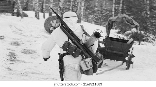 German Wehrmacht Infantry Soldier In World War II Soldiers Running With Anti-tank Gun Panzerschreck In Winter Forest. Historical Re-enactment. WWII. Winter Snowy Day. Black And White Photo.