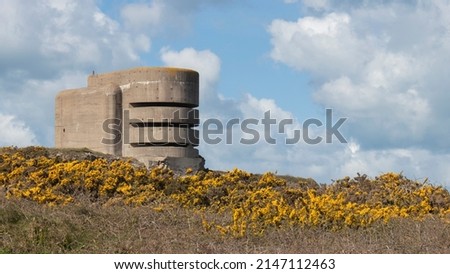 German world war 2 range finding tower called the Odeon on Alderney Channel Islands with wild gorse in bright yellow flowers in front 