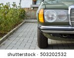 German youngtimer sedan of the seventies and eighties with double headlights in dark green