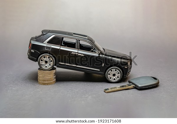 Germany\
02.2021.Car price. The cost of auto parts. On a black background,\
there is a model car .Around the coin. The concept of the growth of\
the transport market and car\
prices.Editorial
