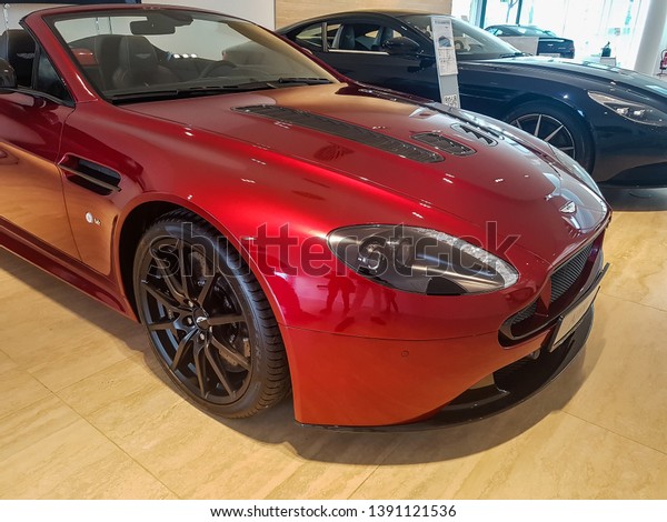 München, Germany, 1.4.2019: Car\
Store Aston Martin in München. Aston Martin DBS cabrio in red\
color.